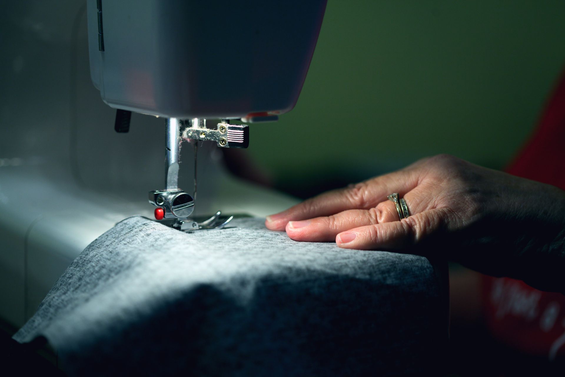 Nähmaschine und Hand auf Stoff